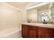 Bathroom features a tub, shower, double sink with wood cabinets, and a large mirror at 11953 Haven St, Las Vegas, NV 89183