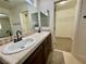 Bathroom vanity with double sinks, tile countertops, and a walk-in closet at 11953 Haven St, Las Vegas, NV 89183