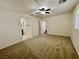 Bedroom features neutral carpet, ceiling fan and entrances to bathroom and hallway at 11953 Haven St, Las Vegas, NV 89183