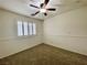 Bedroom featuring neutral paint and carpet, a ceiling fan, and a window with bright white shutters at 11953 Haven St, Las Vegas, NV 89183