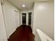 Hallway with wood floors and white walls, featuring multiple doorways at 11953 Haven St, Las Vegas, NV 89183