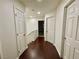Hallway with wood floors and white walls, featuring multiple doors at 11953 Haven St, Las Vegas, NV 89183