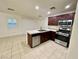Bright kitchen offers stainless appliances, tile flooring and countertops, and dark wood cabinets at 11953 Haven St, Las Vegas, NV 89183