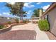 Landscaped backyard with a patio, walkway, and mature trees at 1219 Heather Oaks Way, North Las Vegas, NV 89031