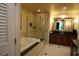 Bathroom features a soaking tub, glass shower, and double sink vanity with a dark countertop at 145 E Harmon Ave # 27621, Las Vegas, NV 89109