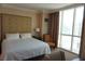Bedroom features a queen bed, a chair, and curtains at 145 E Harmon Ave # 27621, Las Vegas, NV 89109