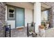 Charming front porch featuring a blue door, decorative plants, and stone accents at 1474 Whistling Kite St, Las Vegas, NV 89138