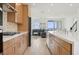 Modern kitchen featuring stainless steel appliances, light wood cabinets, and an open layout to the living area at 1474 Whistling Kite St, Las Vegas, NV 89138