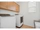 The laundry room has a side-by-side washer and dryer, cabinets for storage, and a window with blinds at 1474 Whistling Kite St, Las Vegas, NV 89138