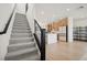 Staircase that leads to open kitchen with stainless steel appliances and large center island at 1474 Whistling Kite St, Las Vegas, NV 89138