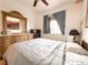 Relaxing bedroom with large dresser, ceiling fan, and window with curtains at 1515 Fort Dix Cir, North Las Vegas, NV 89031