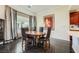 Elegant dining area featuring a round wooden table, stylish chairs, and natural light from a large window at 1609 Hidden Spring Dr, Las Vegas, NV 89117