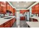 Well-lit kitchen featuring cherry wood cabinets, stone countertops, and stainless steel appliances at 1609 Hidden Spring Dr, Las Vegas, NV 89117