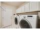 Well-equipped laundry room with white cabinets and modern washer and dryer at 1609 Hidden Spring Dr, Las Vegas, NV 89117