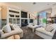 Bright living room with large windows, plush sofas, decorative shelving, and an attractive fireplace at 1609 Hidden Spring Dr, Las Vegas, NV 89117