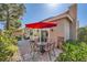 Outdoor patio with dining set, red umbrella and lush green plants at 1609 Hidden Spring Dr, Las Vegas, NV 89117
