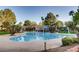 Community swimming pool with clear blue water, surrounded by lush landscaping and lounge chairs at 1609 Hidden Spring Dr, Las Vegas, NV 89117