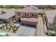 Aerial view of a two-story home featuring a terracotta roof, solar panels, three-car garage, and well-manicured landscaping at 1699 Sonoran Bluff Ave, Henderson, NV 89014