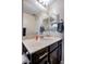 Well-lit bathroom featuring a granite countertop, dark cabinets and ample mirror space at 1699 Sonoran Bluff Ave, Henderson, NV 89014