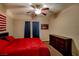 Spacious bedroom with a red comforter, matching drapes, and a ceiling fan at 1699 Sonoran Bluff Ave, Henderson, NV 89014