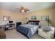 Bright bedroom with plush carpet, a ceiling fan, natural light, and a comfortable chair and desk at 1699 Sonoran Bluff Ave, Henderson, NV 89014