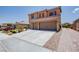 A two-story home exhibits a spacious two-car garage complemented by meticulous landscaping and a brick-paved walkway at 1699 Sonoran Bluff Ave, Henderson, NV 89014