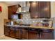 Close up of the kitchen with stainless steel range hood and granite countertops at 1699 Sonoran Bluff Ave, Henderson, NV 89014