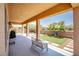 Relaxing covered patio featuring a view of the backyard's lush landscaping with decorative plants in garden beds at 1699 Sonoran Bluff Ave, Henderson, NV 89014