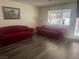 Living room featuring hardwood floors, a front facing window and two red couches at 2108 Willowbury Dr # B, Las Vegas, NV 89108