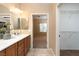 Bathroom featuring double sinks, wood cabinets, tile flooring, and closet at 2708 Cheer Pheasant Ave, North Las Vegas, NV 89084