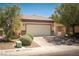 Charming single-story home featuring a two-car garage, desert landscaping, and mature trees at 2708 Cheer Pheasant Ave, North Las Vegas, NV 89084