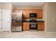 Functional kitchen featuring stainless steel appliances, wooden cabinets, and tile floors for easy maintenance at 2708 Cheer Pheasant Ave, North Las Vegas, NV 89084