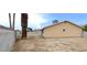 View of the exterior backyard featuring mature trees, a block fence, and covered patio at 275 Las Palmaritas Dr, Las Vegas, NV 89110