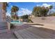 Lush backyard oasis with a sparkling pool, palm trees, wooden deck, and serene landscaping at 2812 Via Avanti St, Henderson, NV 89074
