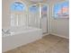Bright bathroom featuring tile floors, a clear glass shower enclosure, and a relaxing soaking tub at 2812 Via Avanti St, Henderson, NV 89074
