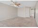 Large bedroom with a ceiling fan and neutral carpeting with multiple windows for natural light at 2812 Via Avanti St, Henderson, NV 89074
