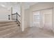 Carpeted hallway with staircase and view to another room with natural lighting at 2812 Via Avanti St, Henderson, NV 89074