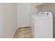 Bright laundry room featuring a white washing machine, neutral tile flooring, and ample storage space at 2812 Via Avanti St, Henderson, NV 89074