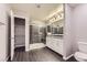 Modern bathroom featuring a walk-in shower with dark stone and a vanity with white cabinets at 2878 Via Firenze, Henderson, NV 89044