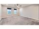 Spacious bedroom with two windows, neutral carpet, and a ceiling fan with lights at 2878 Via Firenze, Henderson, NV 89044