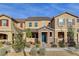 Beautiful townhome with stone accents, inviting landscaping and a stylish teal-colored front door at 2878 Via Firenze, Henderson, NV 89044