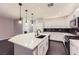 Well-lit kitchen features a large island, black backsplash, stainless appliances, and sleek white cabinets at 2878 Via Firenze, Henderson, NV 89044