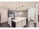 Bright, modern kitchen with a large island, stainless steel appliances, and dark wood floors at 2878 Via Firenze, Henderson, NV 89044