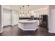 Modern kitchen boasts a large island, sleek countertops, stainless appliances, and stylish pendant lighting at 2878 Via Firenze, Henderson, NV 89044