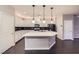 Modern kitchen features stainless appliances, sleek white cabinets, and a large center island with pendant lighting at 2878 Via Firenze, Henderson, NV 89044