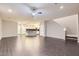 Open-concept living area with kitchen view, featuring wood-style flooring and a ceiling fan at 2878 Via Firenze, Henderson, NV 89044