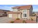 Two-story home boasts a terracotta roof, a two car garage, and charming landscaping leading to the front door at 3008 Soledad Dr, Laughlin, NV 89029