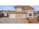 Two-story house boasts a terracotta roof, a two car garage, and charming landscaping leading to the front door at 3008 Soledad Dr, Laughlin, NV 89029