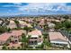 Elevated view of desert home, landscaping, and patio, set against a scenic backdrop of mountains and neighborhood at 301 Lakewood Garden Dr, Las Vegas, NV 89148