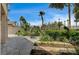 Beautiful backyard garden with decorative water fountain, palm trees, and lush, manicured landscape at 301 Lakewood Garden Dr, Las Vegas, NV 89148